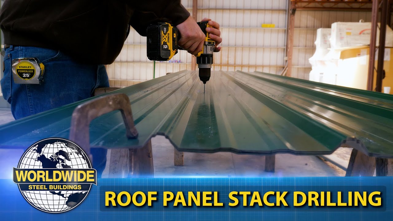 A person is expertly drilling a green roof panel in a warehouse, showcasing an essential step in metal building assembly. The image features text: "Worldwide Steel Buildings" and "Roof Panel Stack Drilling," with tools like a tape measure and drill visible, emphasizing precision installation.